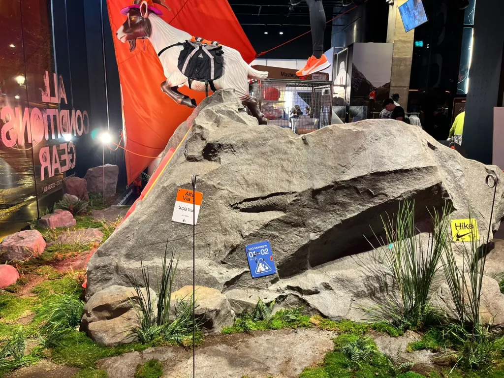 Lower rock display for mountain clothing with planting and a mannequin